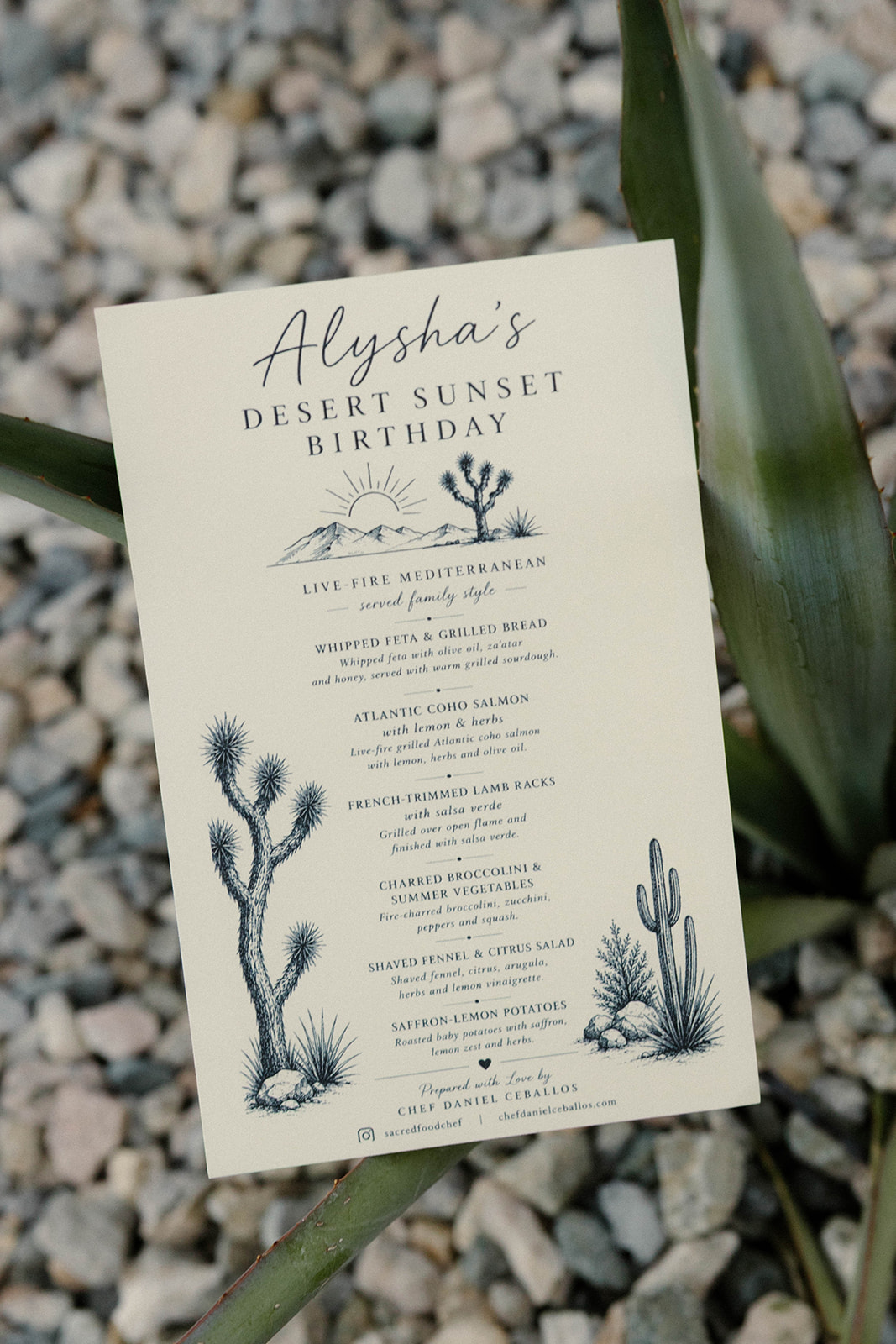 Hand-lettered printed dinner menu resting on an agave leaf